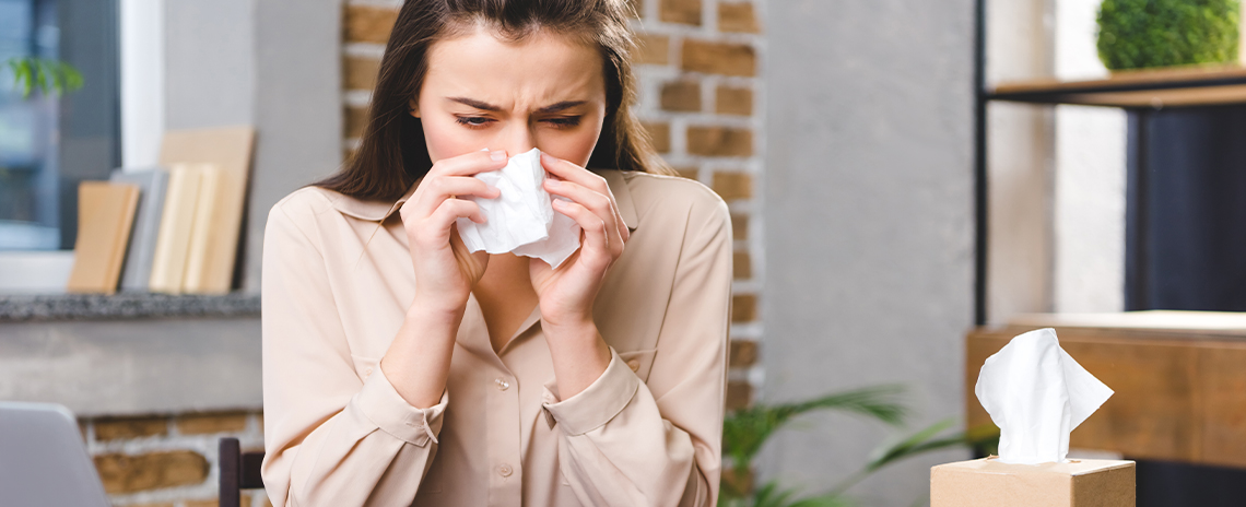 Woman suffering from horrible alergies at work