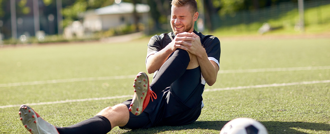 Soccer player suffering with sports injury