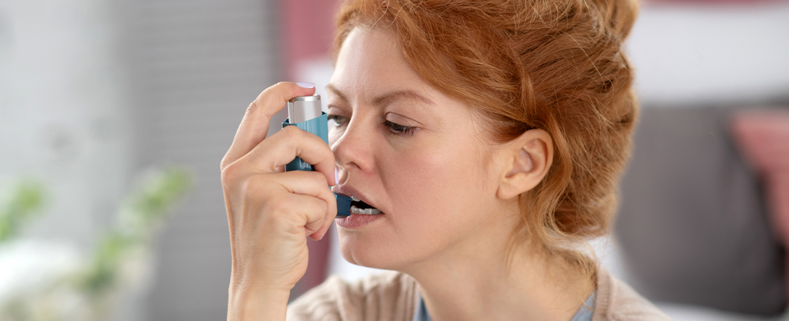 Woman using inhaler for asthma