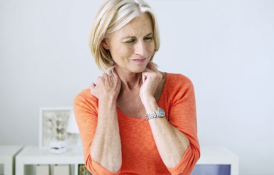 Woman holding neck in pain