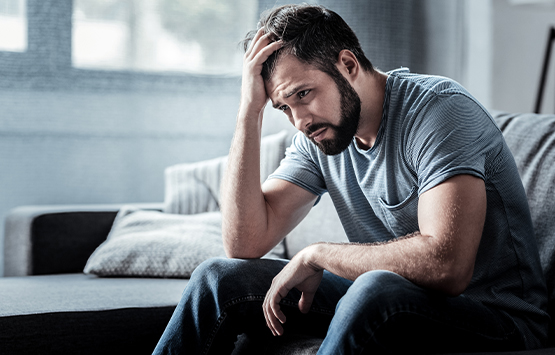 Man sitting on couch dealing with stress at home