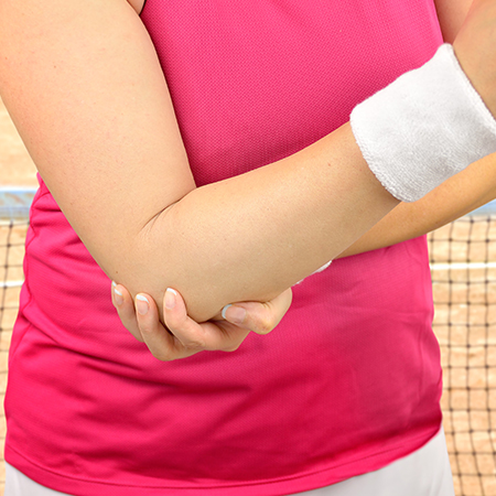 Woman suffering with tennis elbow in need of chiropractic care in San Rafael